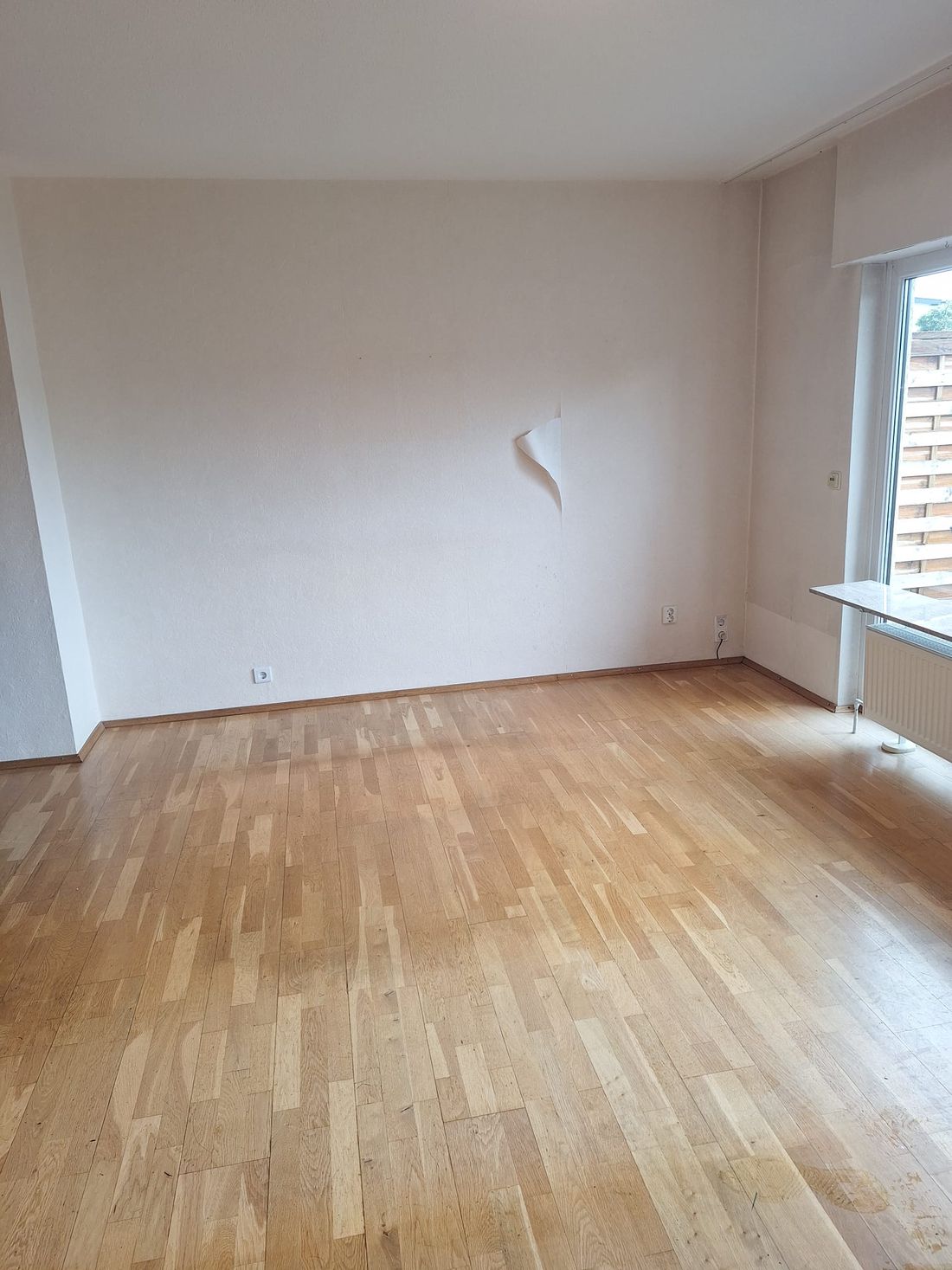 Dasselbe Wohnzimmer nach der Entrümpelung, leer und besenrein